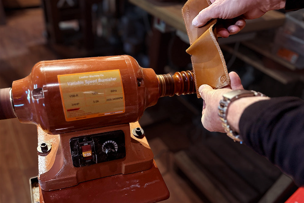 Person polishes a leather wallet edge with the burnishing tool