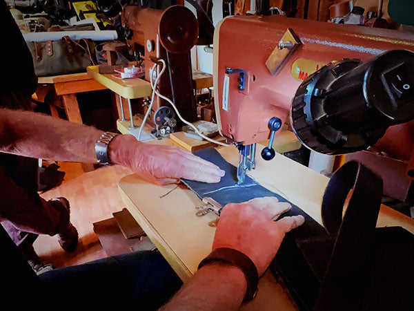 Person sewing a piece of leather with the sewing machine