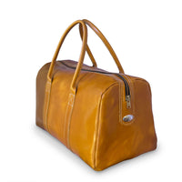 A tan leather duffel bag with dual top handles, a zippered top closure, and a small oval metal logo badge on the front, shown on a white background.